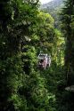 Tourists ride an aerial tram ride through the rainforest canopy of Veragua Rainforest Research and Adventure Park near Limon, Costa Rica.