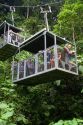 Tourists ride an aerial tram ride through the rainforest canopy of Veragua Rainforest Research and Adventure Park near Limon, Costa Rica.