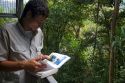 Naturalist guide reading a field guide in the Veragua Rainforest Research and Adventure Park near Limon, Costa Rica.