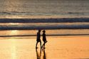 People walk on the beach at sunset in Jaco, Costa Rica.