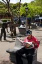Costa Rican man reading a newspaper in San Jose, Costa Rica.