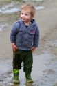 Young boy playing in mud puddles at Skagit Valley, Washington, USA.