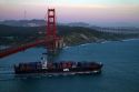 Container ship and the Golden Gate Bridge at dusk in the San Francisco Bay area, California, USA.