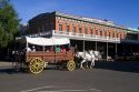 Tourists ride in a horse drawn covered wagon at Old Sacramento State Historic Park in Sacramento, Califorina, USA.