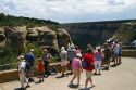 Tourists view cliff dwellings at Mesa Verde National Park located in Montezuma County, Colorado, USA.