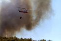 Helicopter with water bucket performing aerial firefighting on a wildfire near Boise, Idaho, USA.