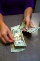 Bank teller counting american dollars at a bank in Boise, Idaho, USA. MR