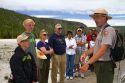 Park ranger giving a tour group information about the Upper Geyser Basin in Yellowstone National Park, Wyoming, USA.