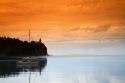 A morning view of Spilt Rock Lighthouse with sailboat and mist on Lake Superior, Minnesota, USA.