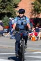 Police officer riding a bicycle at the Trailing of the Sheep Parade on Main Street in Ketchum, Idaho, USA.