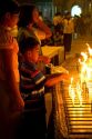 A young boy lighting a candle at the Shwedagon Paya located in (Rangoon)Yangon, (Burma) Myanmar.