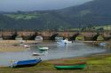 Fishing boats at low tide and the Maza bridge at San Vicente de al Barquera, Cantabria, Spain.