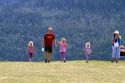 Family of tourists walking on a hillside in Waterton Lakes National Park, Alberta, Canada.