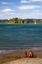 People on the beach at Bay of Islands at the town of Paihia, North Island, New Zealand.