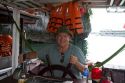 American tourist captoning a tour boat in Ha Long Bay, Vietnam.