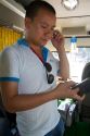 Vietnamese man using a smart phone while talking on a cell phone in Hanoi, Vietnam.