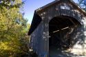 The Mill Covered Bridge crossing the Lamoille River in Belvidere, Vermont, USA.